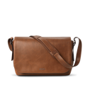 The Runwell Messenger Bag in medium brown by Shinola features a large flap closure, an adjustable crossbody strap, and the Shinola logo embossed near the bottom center. Displayed on a white background.