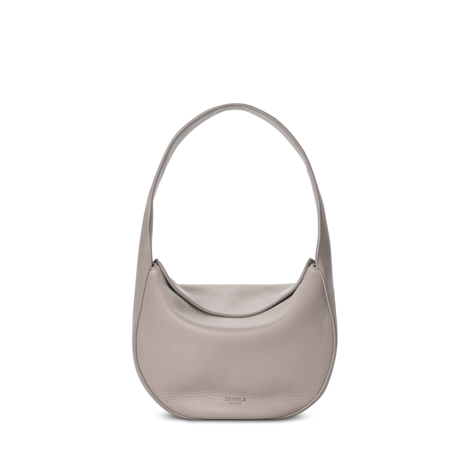 The Shinola Small Shoulder Bag - Taupe features a minimalist crescent-shaped design in premium leather with a wide strap, shown against a white background.
