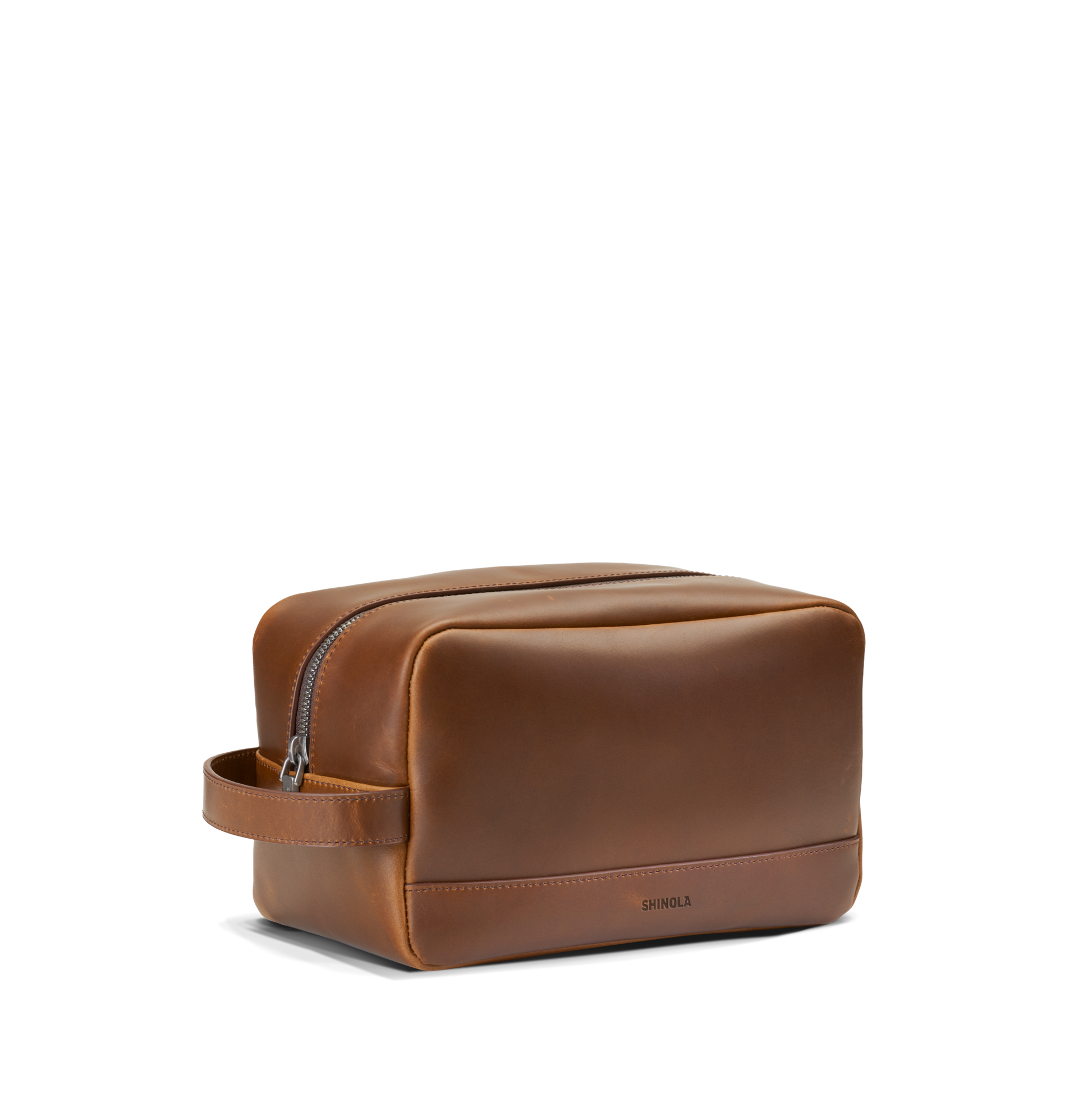 The Zip Travel Kit - Medium Brown by Shinola features a top zipper, side handle, and Shinola embossed on the lower front, shown against a plain white background.