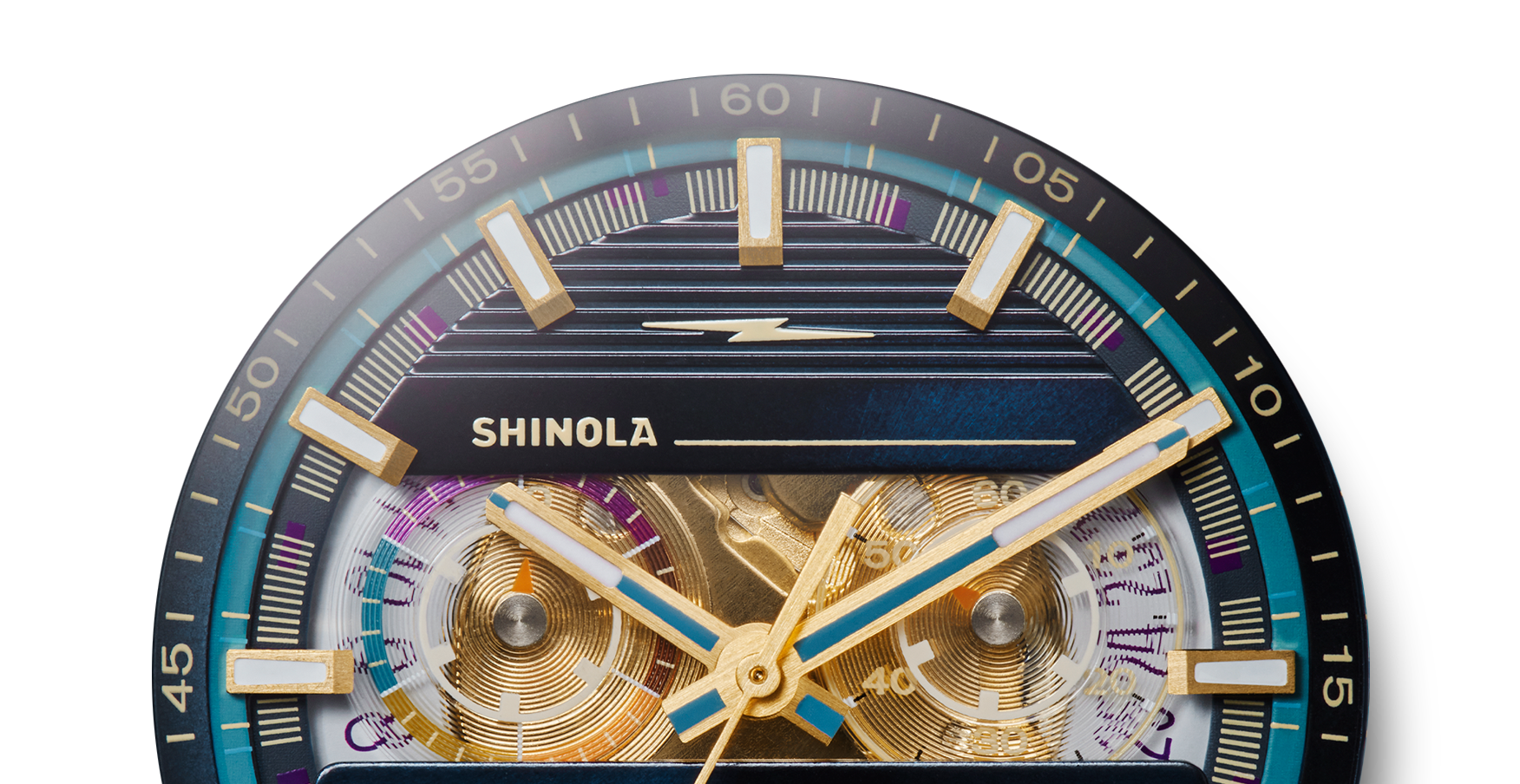 Close-up of a Shinola J Dilla Runwell Chronograph Watch - Midnight Blue face with gold and blue hands, bold hour markers, detailed minute indicators, and visible gears on a dark blue outer ring.