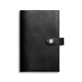 The Shinola Medium Snap Journal Cover in black Vachetta features visible edge stitching and a sleek, sophisticated design, with a flap closure secured by a snap button for a polished and luxurious Italian leather look.