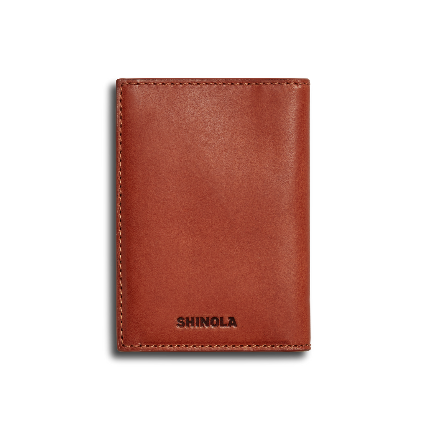 The Shinola Folded Card Holder - Rust is a brown leather wallet made from premium Italian Vachetta leather, featuring visible edge stitching and "SHINOLA" embossed at the bottom, shown closed against a white background.