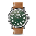 The Shinola Runwell Watch - Green features a brown leather strap, green dial with white numerals, and a small seconds subdial. The stainless steel face is marked "Shinola Argonite-1069 Detroit" at the top.