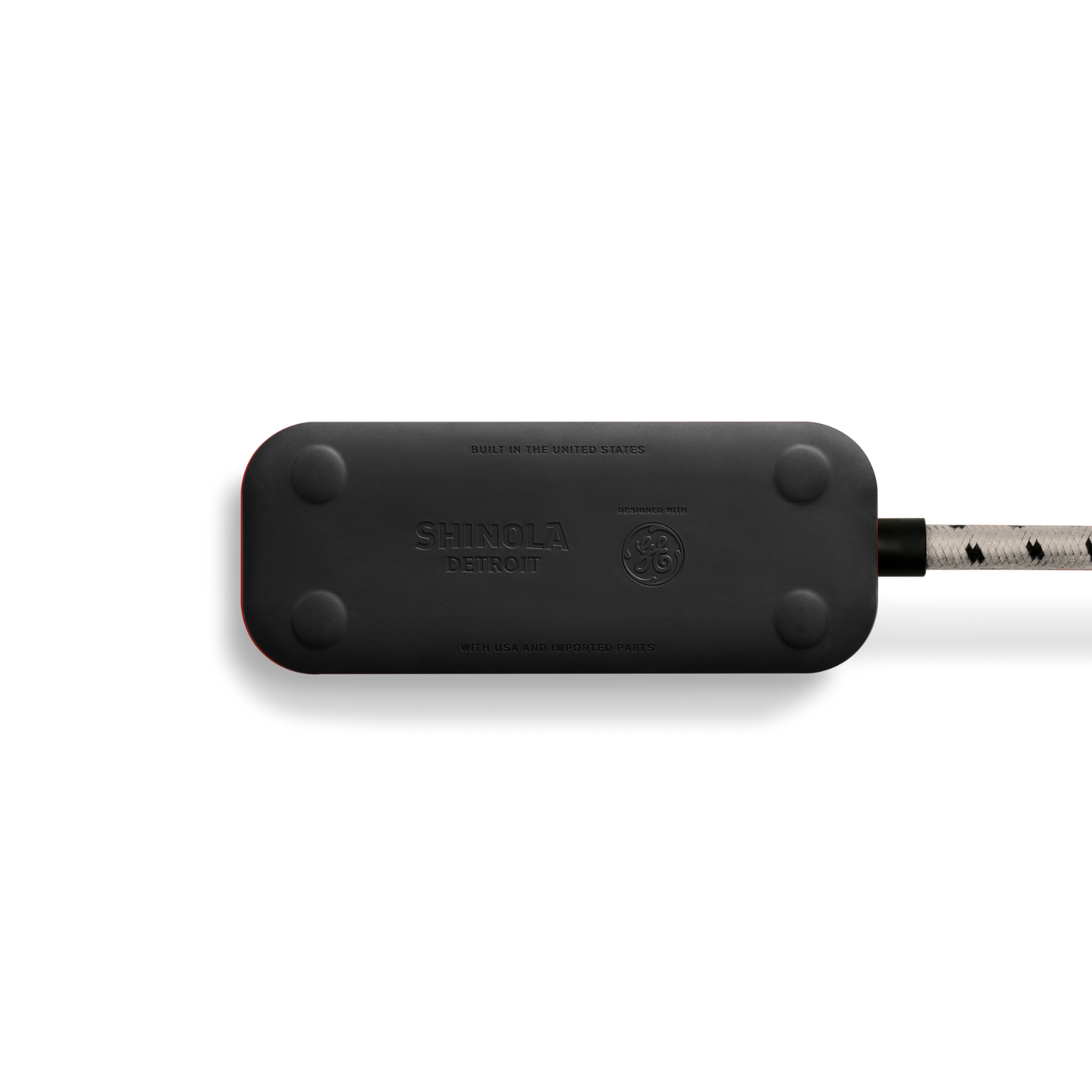 A Shinola 2 Port Power Supply - Stone, featuring die-cast metal accents, rounded edges, and a braided white and black cord, is photographed on a white background.