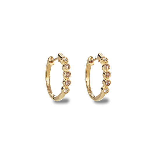 The Desert Diamond Huggie Earrings by Shinola are 14k yellow gold hoops featuring five round, light pink gemstones on each earring, displayed against a plain white background.