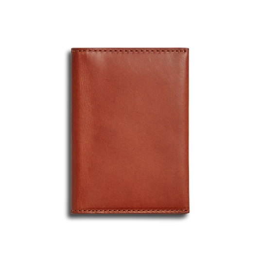 The Shinola Folded Card Holder - Rust is a closed, rectangular wallet crafted from Italian Vachetta leather with visible edge stitching, shown against a plain white background.