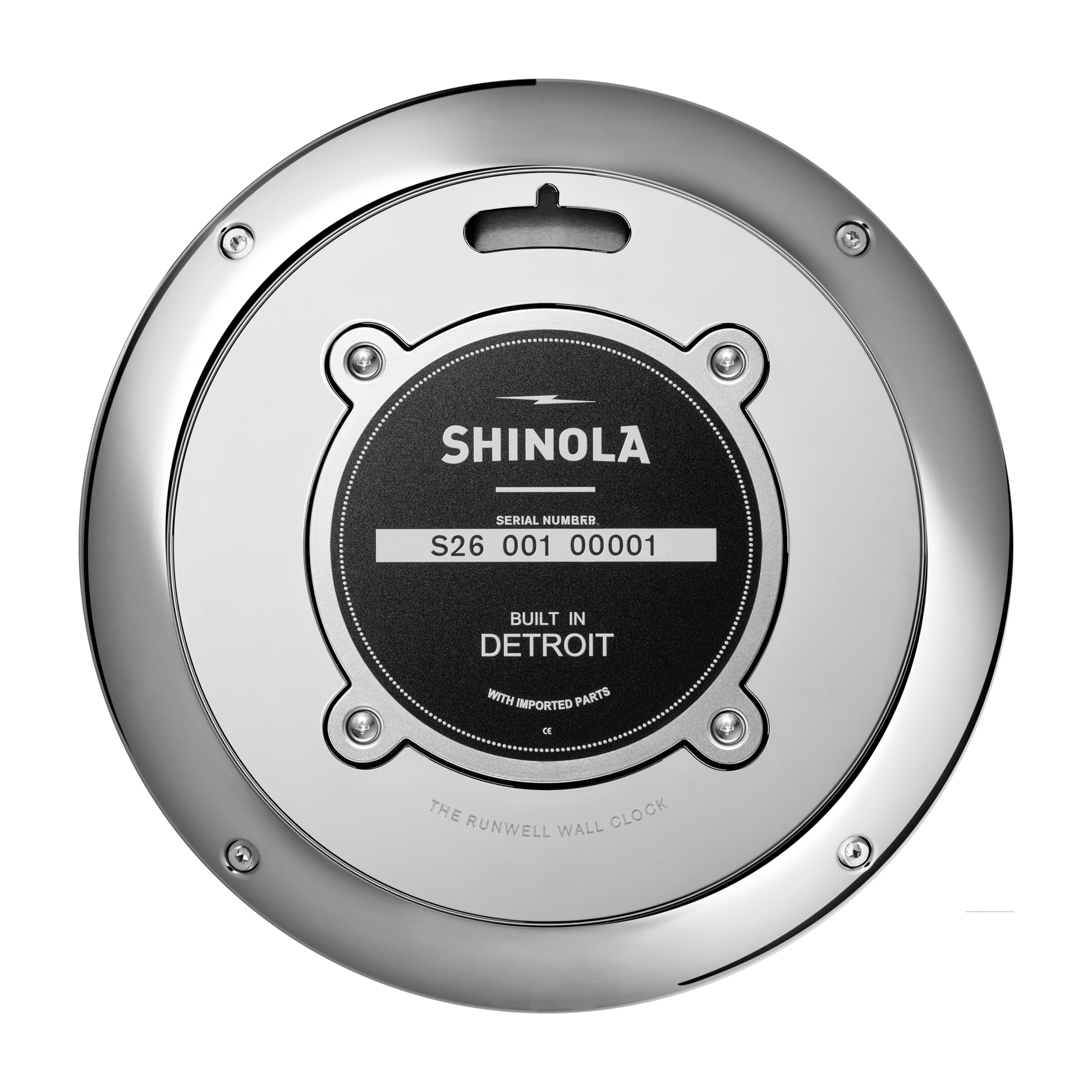 Close-up of the back of a Shinola 14" Runwell Clock - White, highlighting its round metal cover, central Built in Detroit label with serial number and imported parts note, and a shiny chrome casing along the edge.