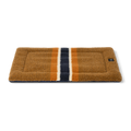 The Shinola Crate Comfort Mat - Stripe Brown features a rectangular brown design with three vertical stripes (navy blue, white, orange) at the center. It's machine washable, perfect as a dog bed or a cozy crate cushion.