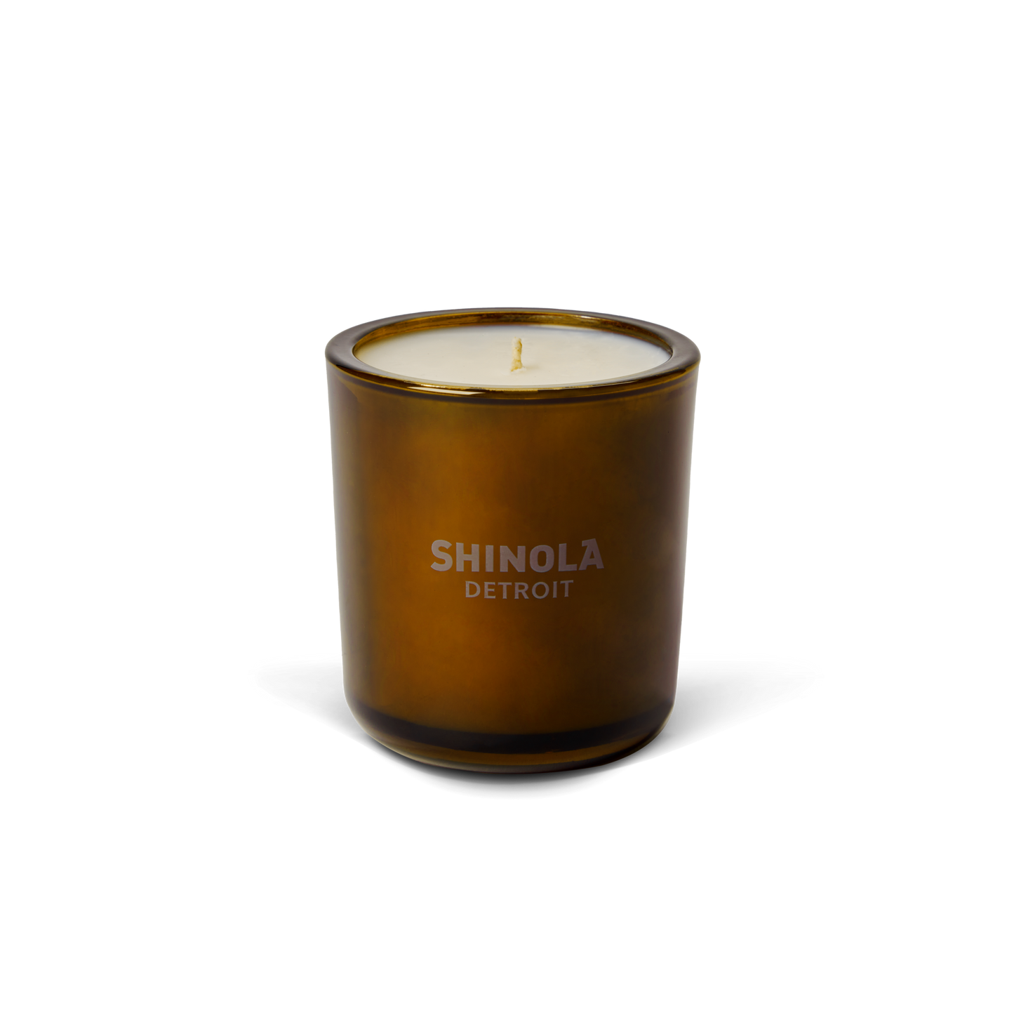 The Shinola Rose 8 oz Scented Candle features cream-colored coconut soy wax in a brown glass jar labeled “SHINOLA DETROIT.” With a subtle floral rose scent, it adds elegance to any space. Shown on a plain white background.