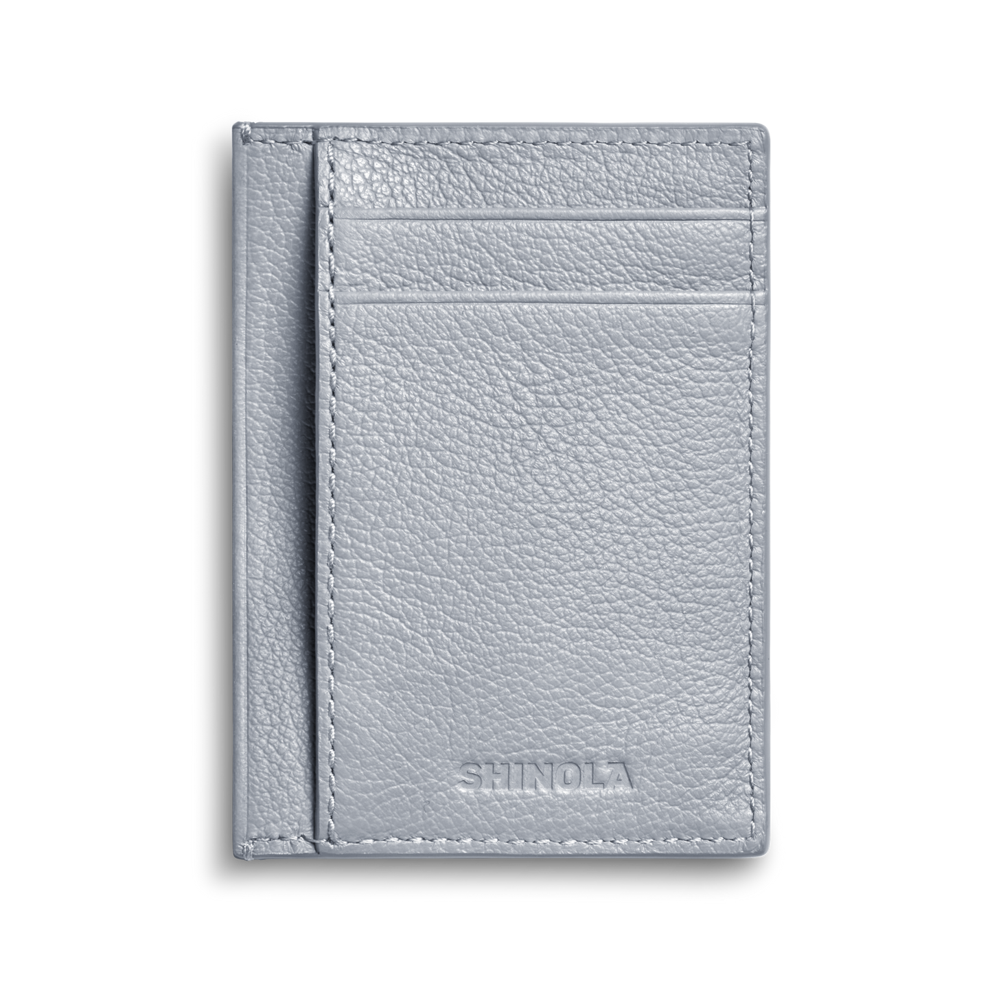 The Canfield ID Card Holder in Mist by Shinola is a slim wallet crafted from light gray pebbled leather, featuring visible stitching, two card slots, and the Shinola logo embossed at the bottom front.