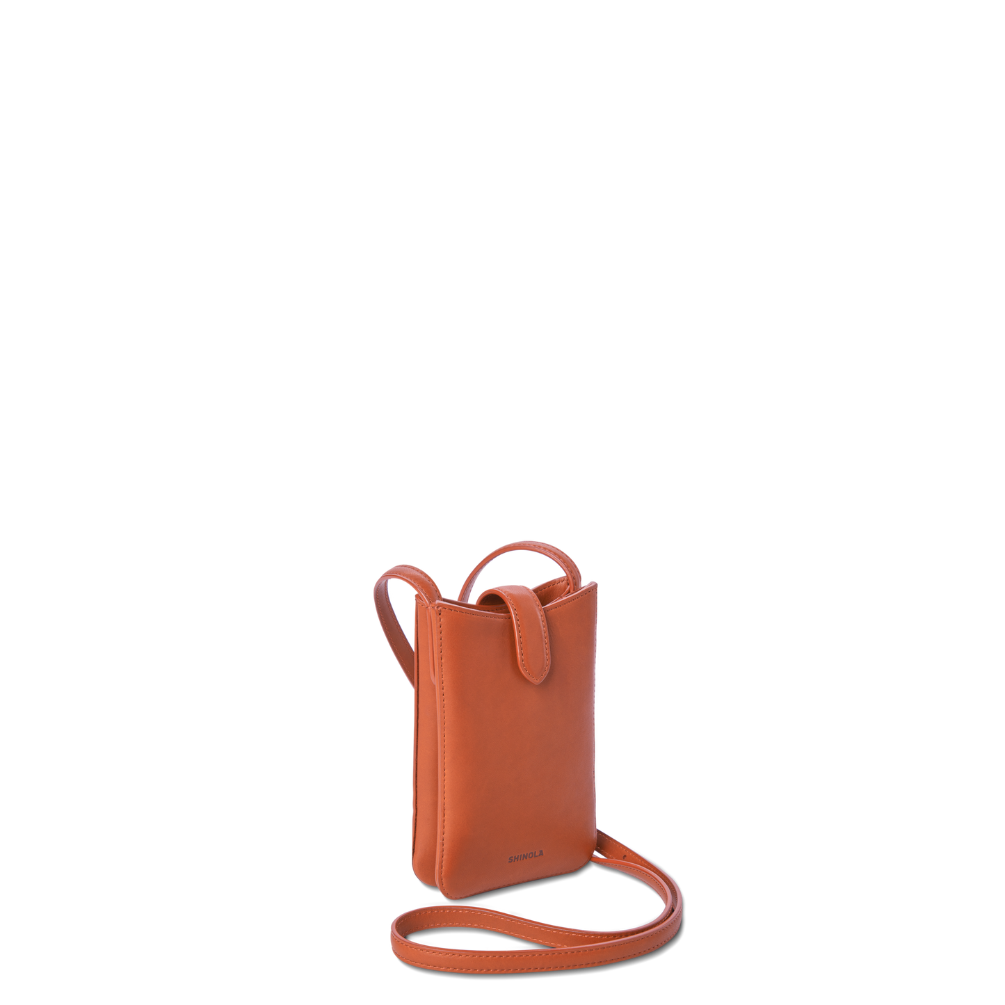 The Shinola Bixby Phone Crossbody - Rust is a small, rectangular natural leather bag with a thin strap, flap closure, and minimalistic design, shown upright on a white background.