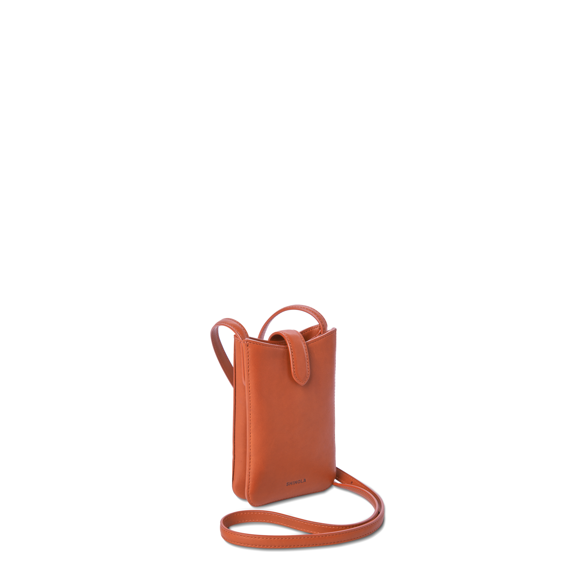 The Shinola Bixby Phone Crossbody - Rust is a small, rectangular natural leather bag with a thin strap, flap closure, and minimalistic design, shown upright on a white background.