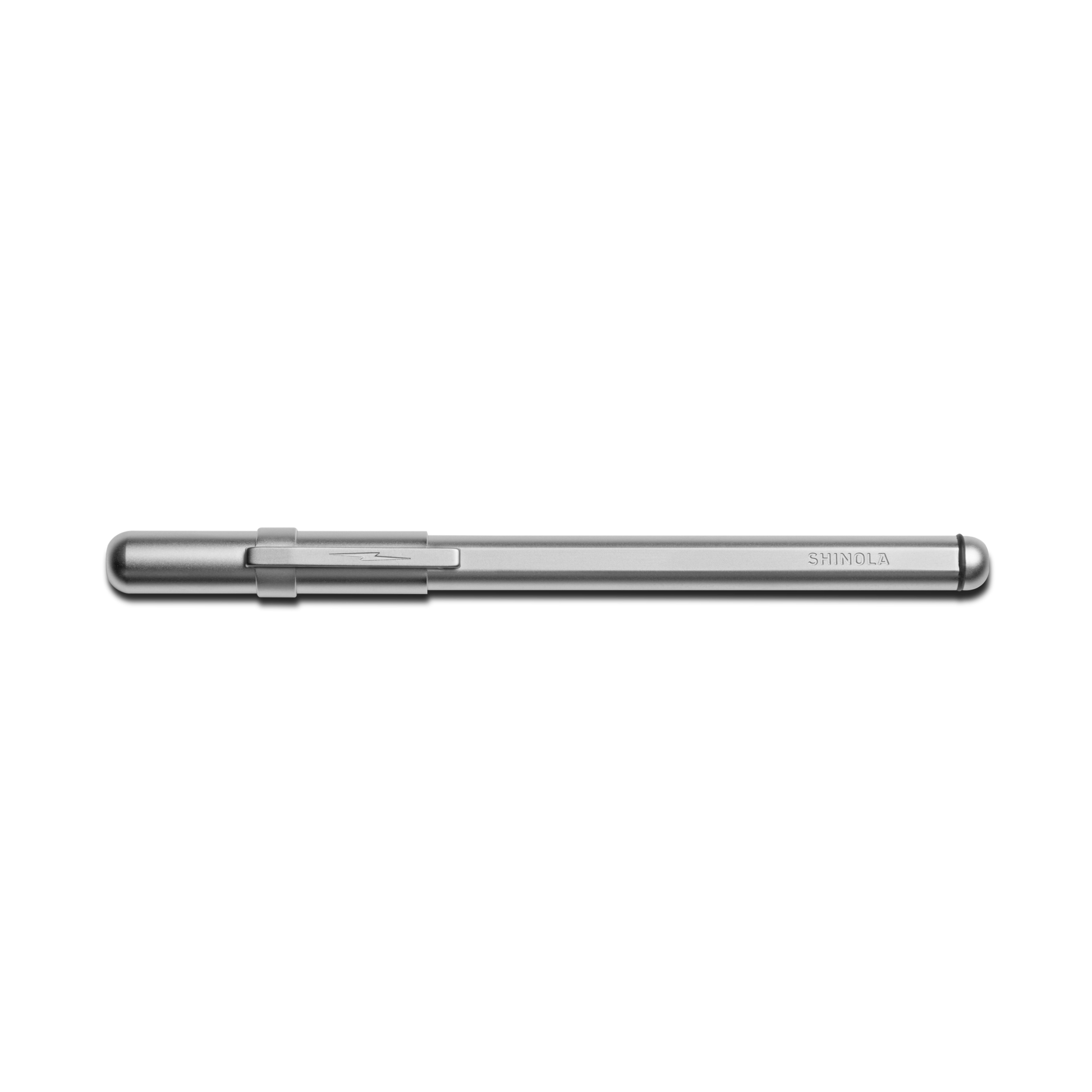 A matte silver Stainless Steel Studio Pen by Shinola with a clipped cap rests horizontally on a white background. The SHINOLA brand name is engraved near the end of this elegant pen's stainless steel barrel.