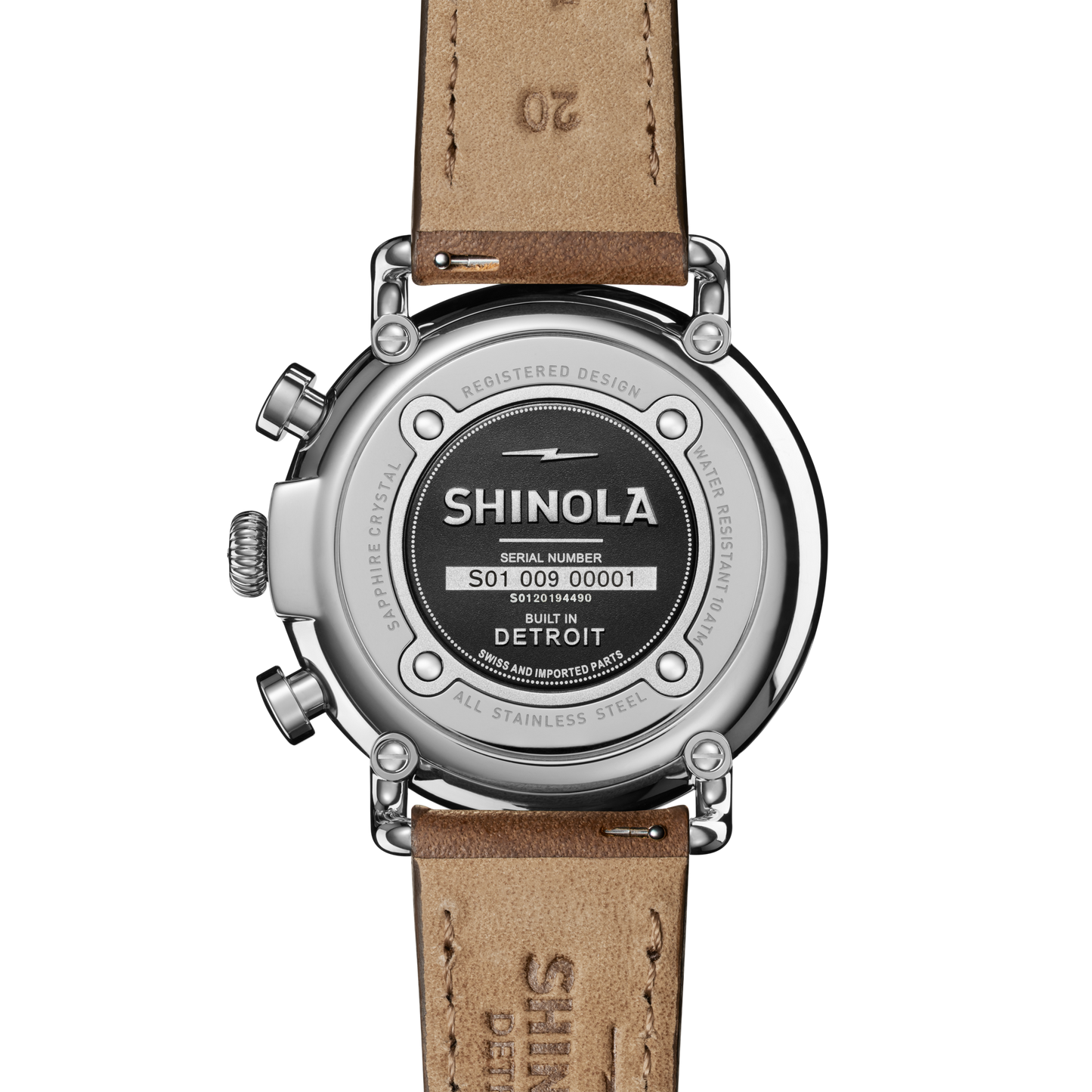 Close-up of the Shinola Runwell Chronograph Watch - Midnight Blue, featuring a brown leather strap and stainless steel case etched with the logo, serial number, and details showing it's built in Detroit with Swiss parts.