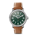 The Shinola Engravable Runwell Watch - Green features a green dial with white numerals, silver case, brown leather strap, the Shinola Detroit logo on the dial, and a small seconds subdial above 6 o’clock.