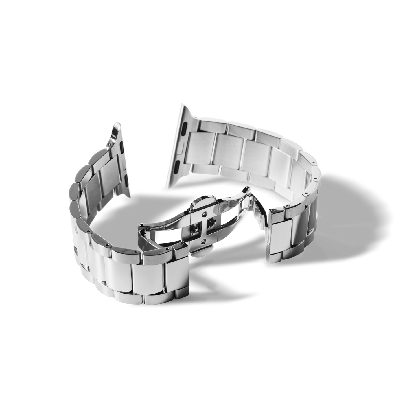 A Shinola 20mm Stainless Steel 3-Link Apple Watch Bracelet with deployment clasp is open and laid out on a white surface, casting soft shadows.