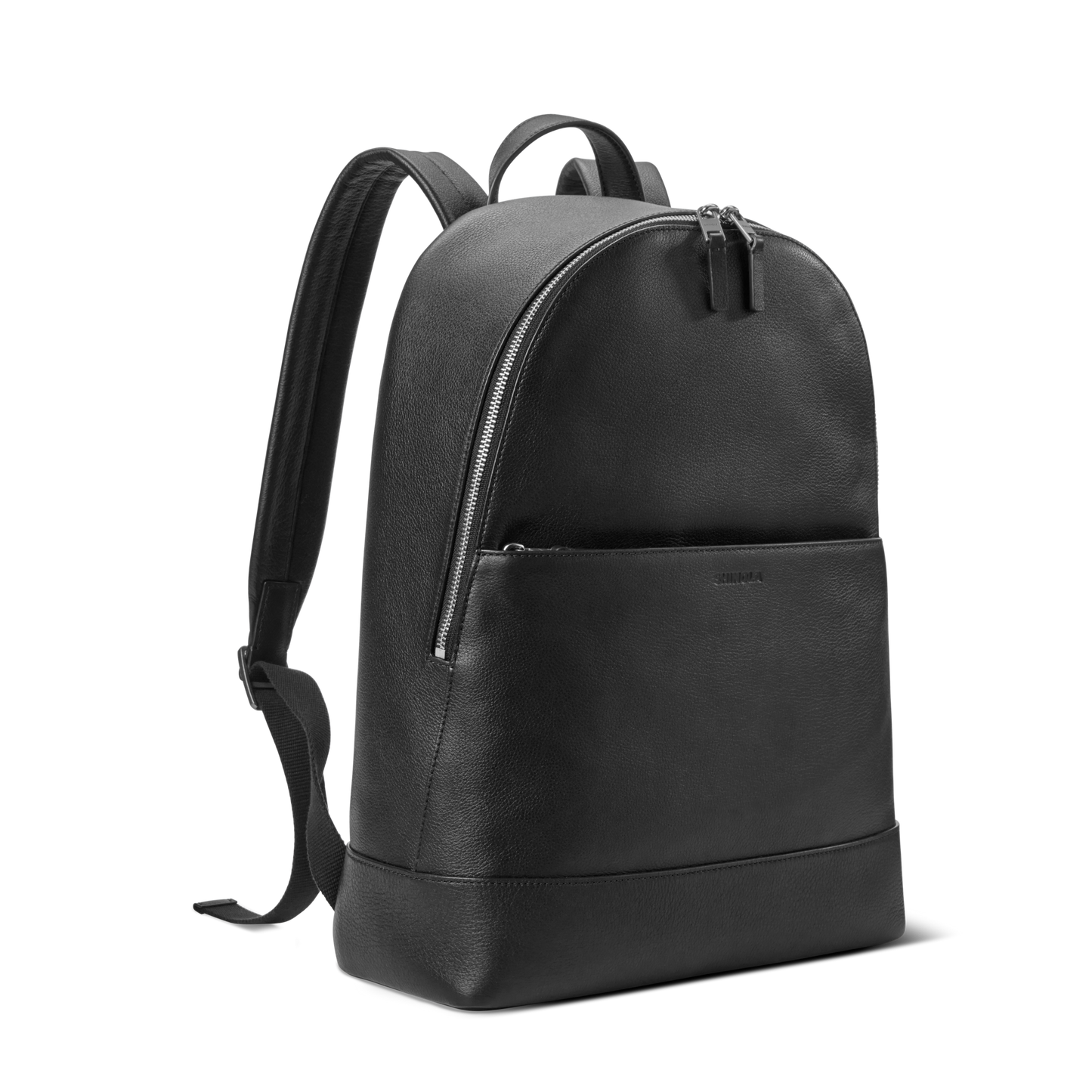 The Shinola Canfield Backpack - Black is a minimalist leather commuter bag with a front zipper pocket, adjustable shoulder straps, and a top handle, shown against a plain white background.