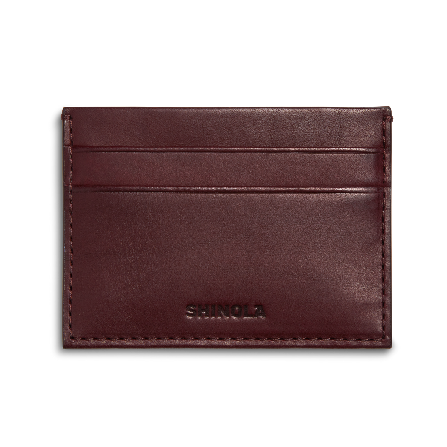 The Pocket Card Holder - Merlot by Shinola is a slim, rectangular dark brown vachetta leather card holder with two card slots and SHINOLA embossed at the bottom center.