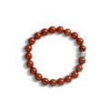 The Shinola 8mm Beaded Red Jasper Bracelet features polished red stones and a sterling silver accent bead engraved with the Shinola logo, shown on a white background.