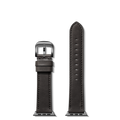 Two Shinola 20mm Black Leather Apple Watch Straps—each with black hardware—are shown vertically on a white background; one has a buckle and loops, the other is longer with adjustment holes, highlighting their craftsmanship.