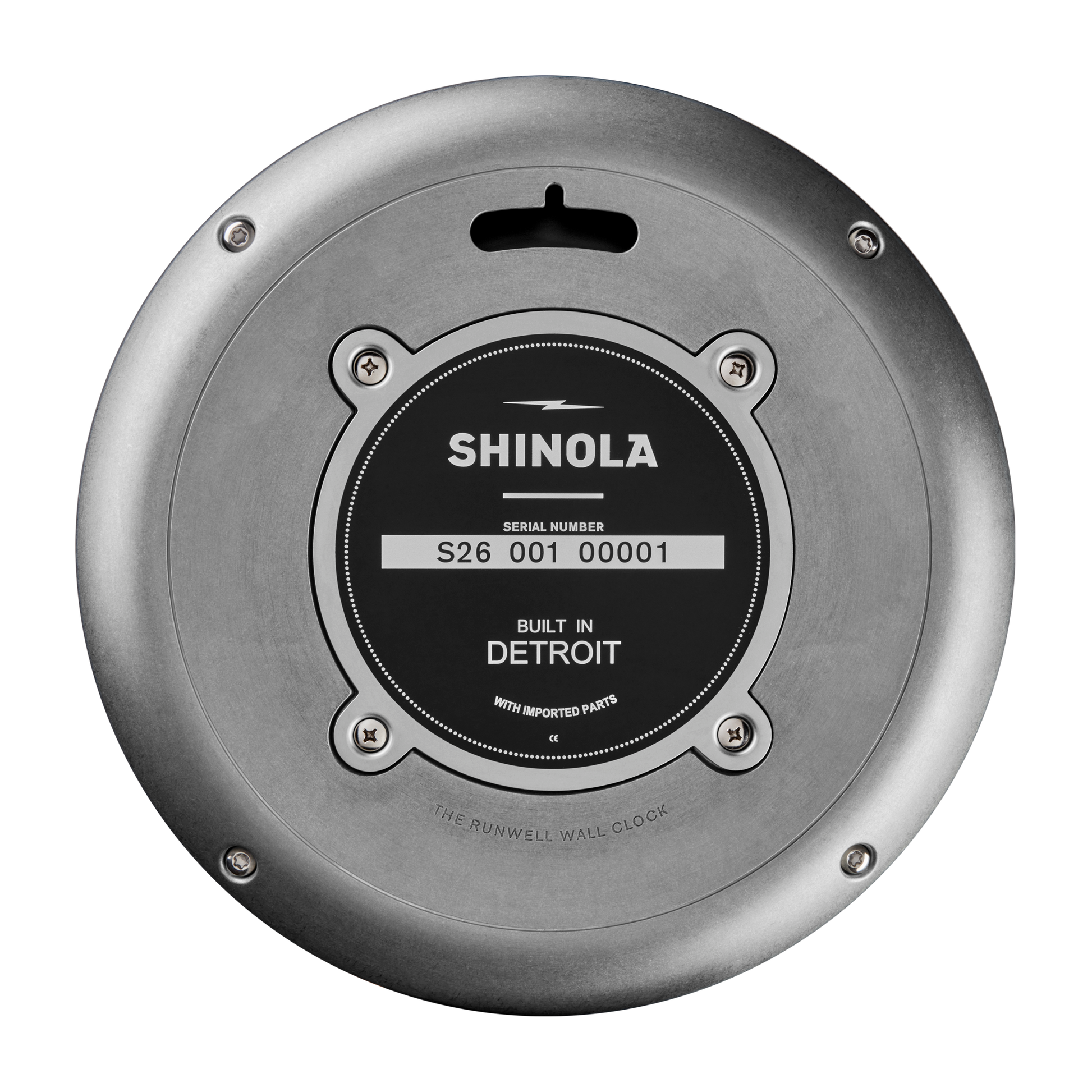 Back view of the Shinola 14" Runwell Clock in Tumbled Zinc/Black shows its industrial design with a tumbled zinc case, serial number S26 001 00001, "Built in Detroit" on the black label, and four screws securing the plate.