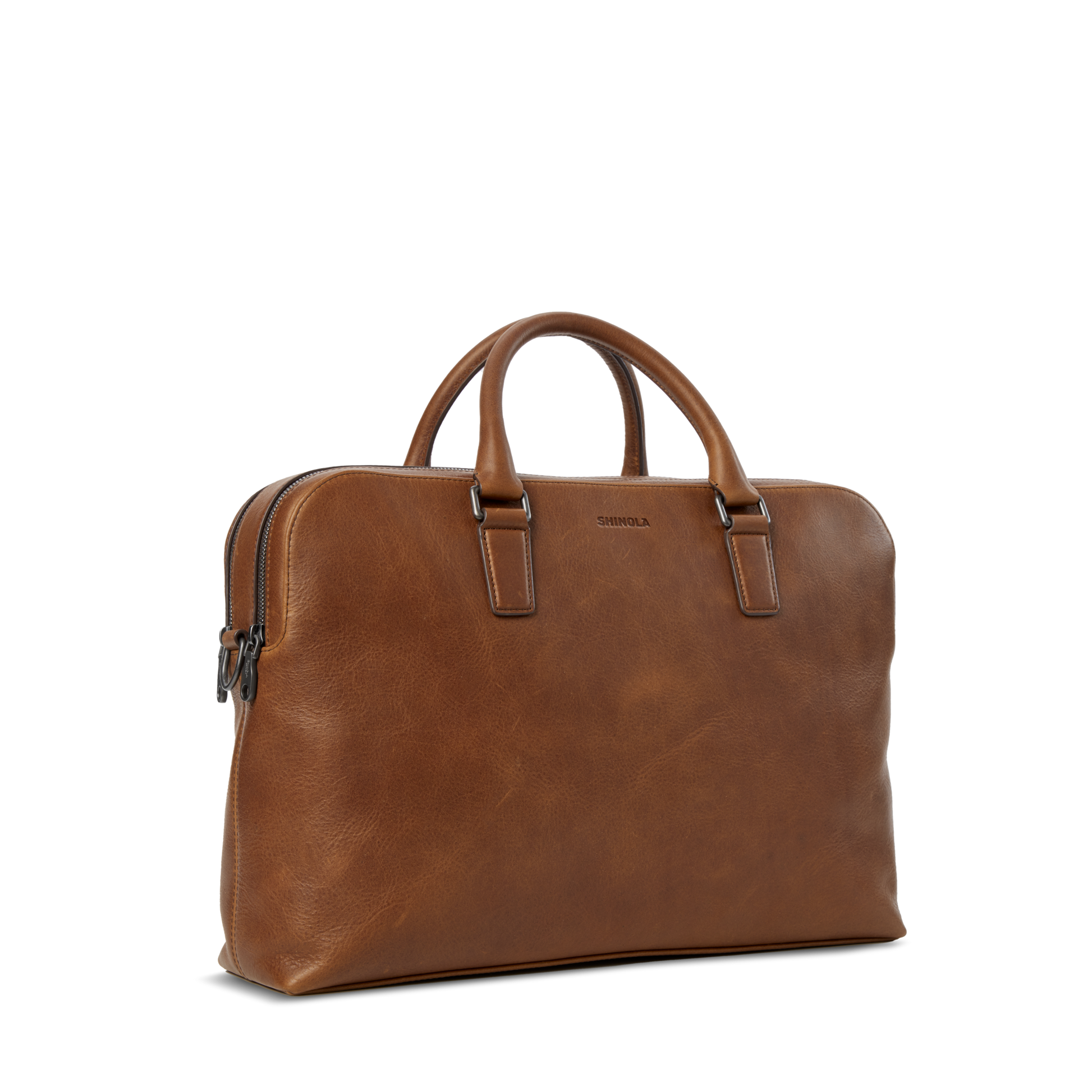 The Shinola Double Zip Briefcase in medium brown leather features two short handles, a zippered top, and a sleek, minimal design. Shown against a plain white background.