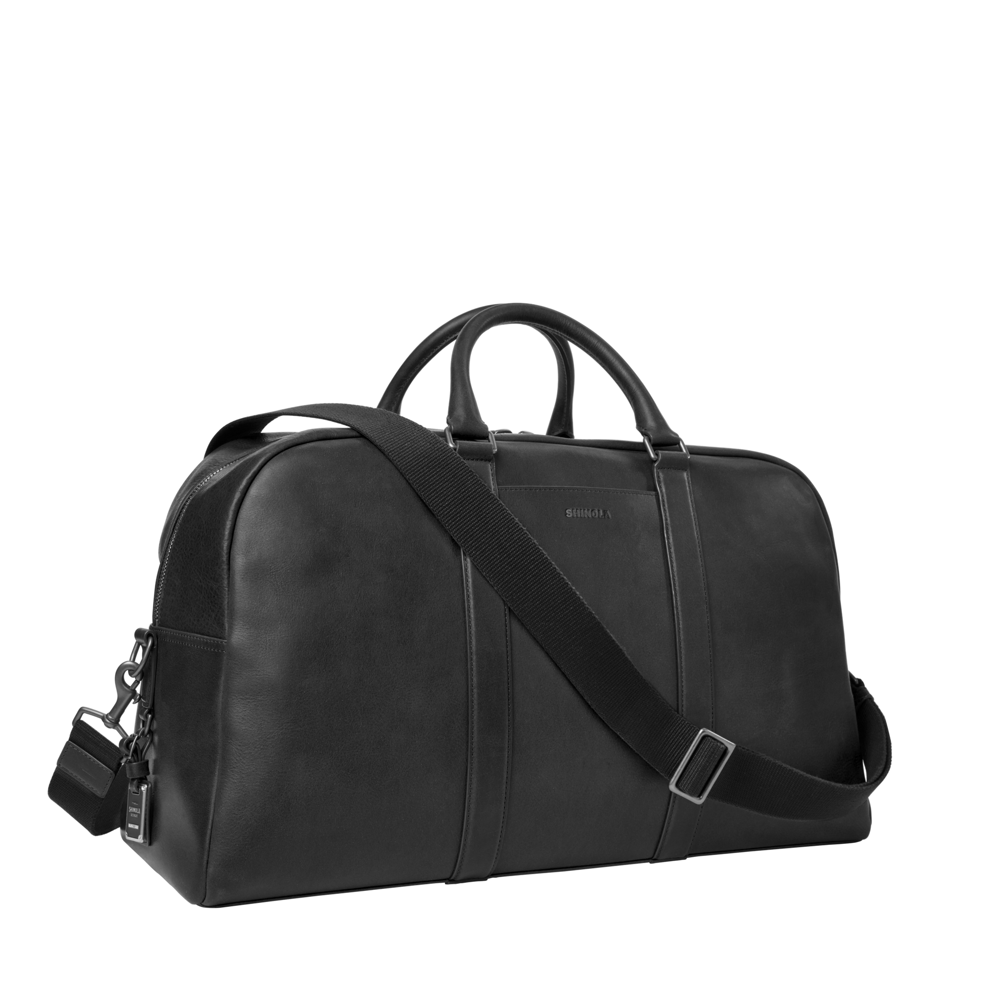 The Shinola Runwell Duffle Bag - Black is crafted from premium Navigator leather with short handles and a detachable, adjustable shoulder strap, shown against a plain white background.
