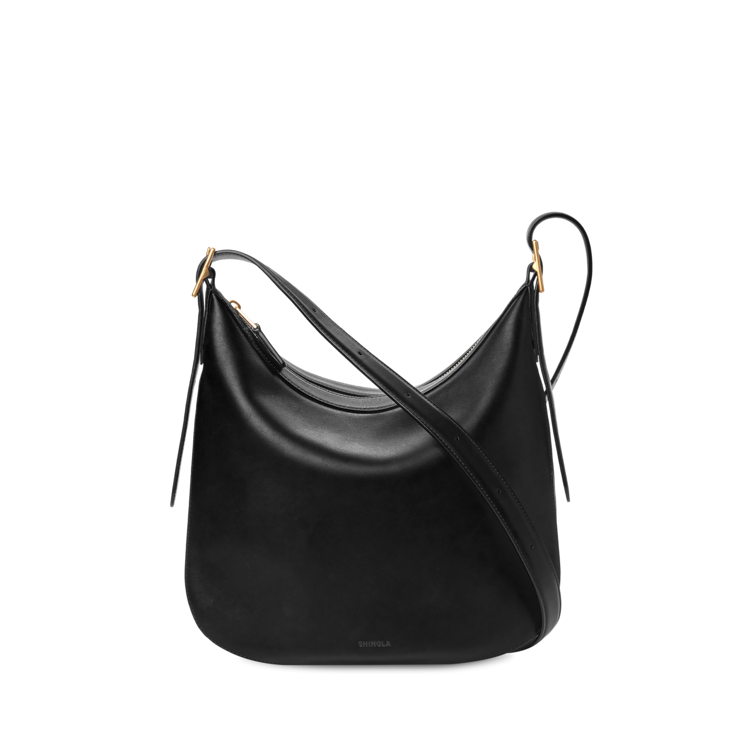 The Shinola Medium Bixby Crossbody - Black features a curved, slouchy shape in natural leather with gold-tone hardware and two adjustable straps, displayed against a plain white background.
